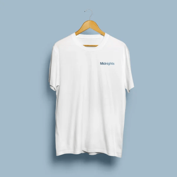 Frente de t-shirt branca com tipografia Midnights em azul aço no peito esquerdo, em cabide de madeira